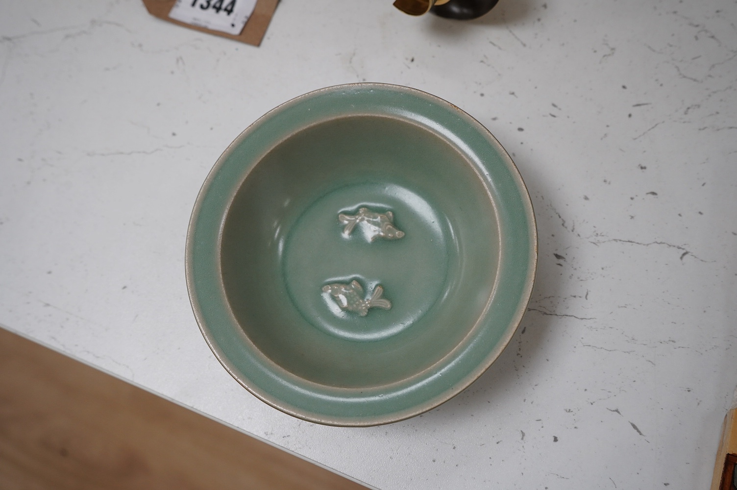 A Chinese cased celadon glazed 'twin fish' marriage dish, 13cm diameter. Condition - good